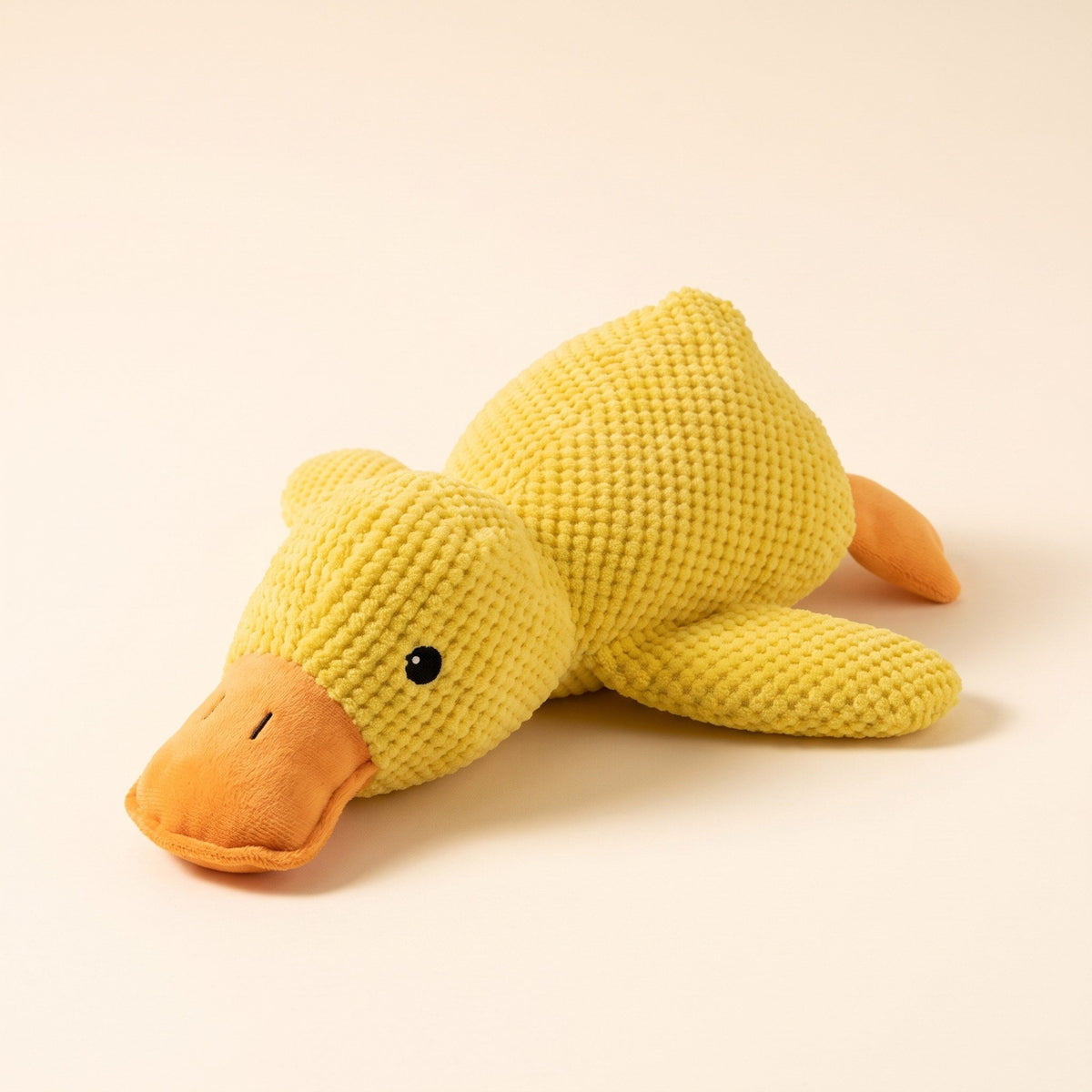 Wuffy SnoozeDuck calming plush duck dog toy in yellow waffle fleece, three-quarter view