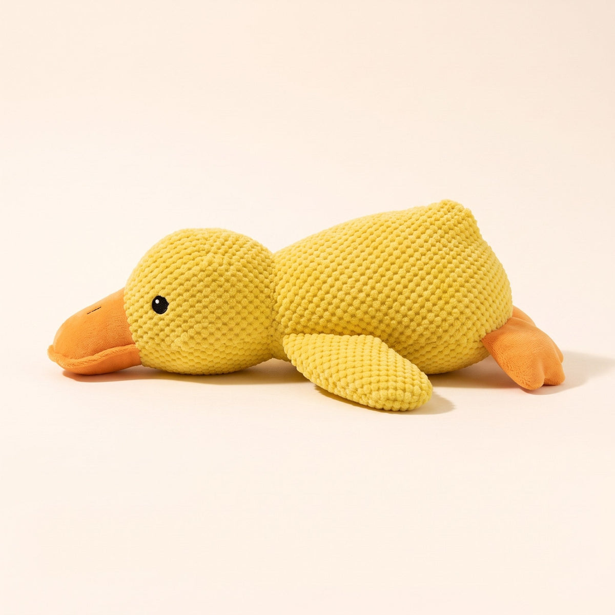 Wuffy SnoozeDuck plush duck dog toy resting on its side, showing the soft orange bill
